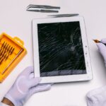 Technicien examinant une tablette ouverte pour diagnostiquer une panne