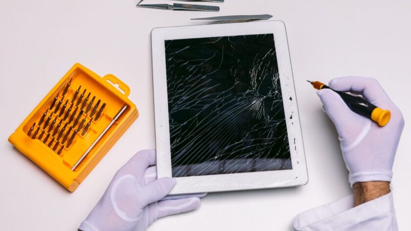 Technicien examinant une tablette ouverte pour diagnostiquer une panne
